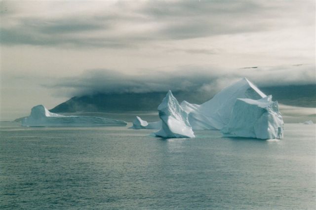 Morgentågen ligger endnu over de op til 2000 meter høje bjerge. Søgangen er minimal. Bemærk, at de tre dele isbjerg hænger sammen under vandet.