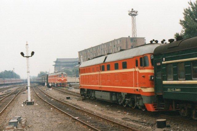 Vi er stadig i Beijing 1995. Til venstre afgår BJ 1660 og 1680 med 15 vogne. Til højre ankommer DF 2477 ligeledes med 15 vogne. Klar til afgang holder DF 4 2332.