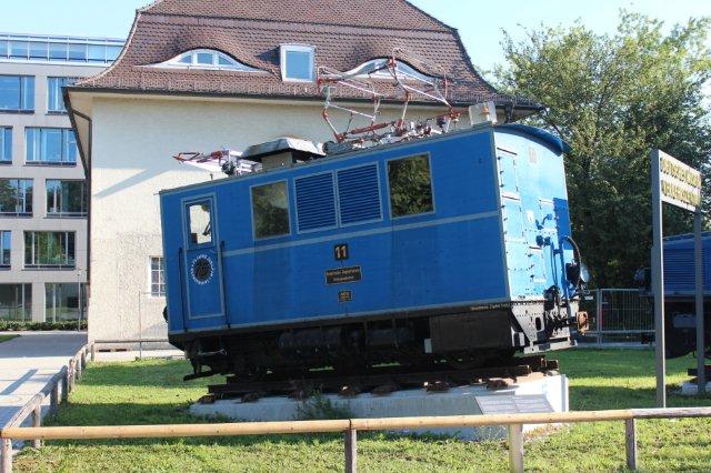 Tandhjulslokomotiv fra Bayrische Zugspitzbahn AG nr. 11. AEG 4260/1930. Der var 8 bjerglokomotiver, 11 - 18. Hvert lokomotiv havde tre tandhjul hver med en motor på 170 kW, altså 510 kW. Vægt på 27,5 t. De kørte 13 km/t opad, men kun 9 km/t nedad og kun med to vogne. Når Riggenbachsystemet ofte ses med to eller tre forskudte tandstænger, er det, fordi hver motor arbejder med eget tandhjul på sin egen tandstang. München 30.08.2013. I dag kører banen med motorvognssæt.