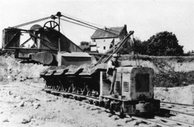 Molbograven lå i 1965, hvor billedet er taget, lidt fra værket i et villakvarter. Lokomotivet er et Henschel. Billedet er lånt på Viby Bibliotek.