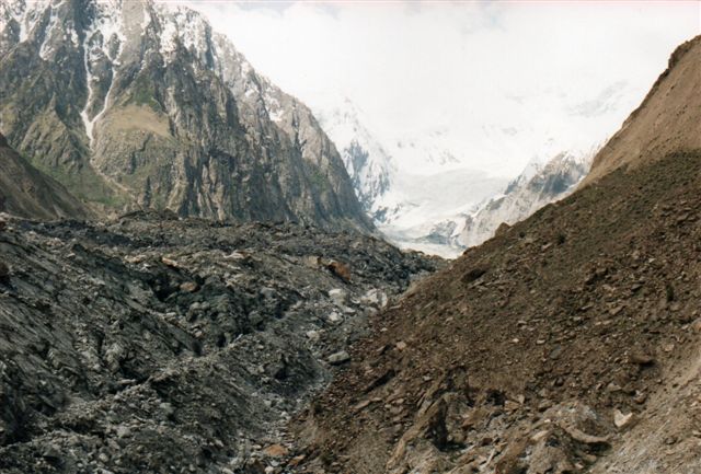 En gletscher i Pakistans del af Himalaya. Den er helt dækket af nedfald, så det er svært at se, hvornår man går på den faste klippe og, hvornår man er ude på gletscheren. Nær gletscherens nedre ende revner den ofte, men formentlig undgik de trådte stier over gletscheren gletscherspalterne, men man ved jo aldrig. Udsynet over gletscheren var også bedre højere oppe igen, så jeg vendte her. Hvis du under dig over alt det, der ligger oven på gletschere, så betænkt, at det meste af Danmark er kommet fra Skandinavien på denne måde! Lokalt kaldte de indfødte den for Hopargletscheren. I virkligheden løb mindst to gletschere sammen højere oppe.
