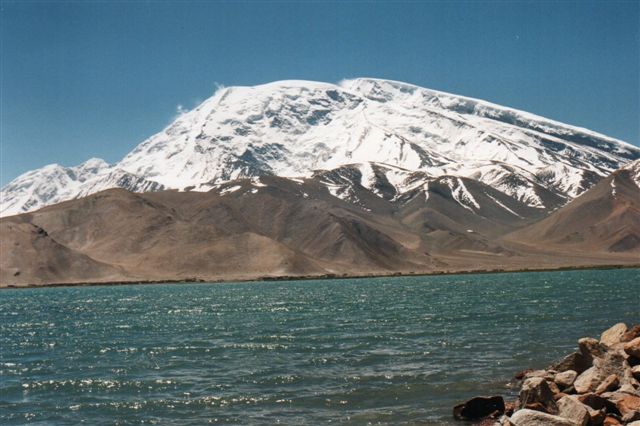 Dette bjerg, Muztagh Ata, Isbjergenes fader, 7546 meter, Kinas tredje højeste bjerg beliggende i Pamir rummer adskillige gletschere, men nu er vi nede i 3300 meter, så der er højt op til gletscherne. Søen er Kara Kul, Den sorte Sø. På et andet foto af bjerget set fra en anden vinkel, ses 7 gletschere. 