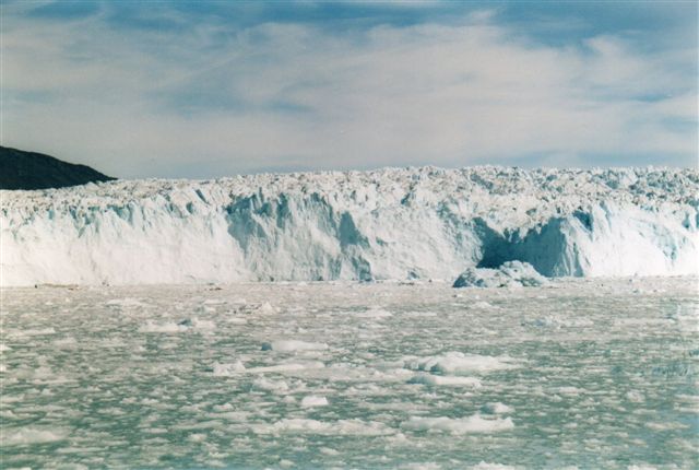 Eqibræen i Grønland 2014. Vi er i Atasund eller Ikerasak nord for Ilulissat. Gletscheren er 50 meter høj fra vandlinje til top. Den kælver ikke før den slipper bunden 350 - 400 meter under havoverfladen. Skipperen her holdt 2 sømils sikkerhedsafstand. Hver gang den kælvede, vippede vi voldsomt. Reklamefotoene fra turen var taget meget tætterepå, men sådan er det jo med reklamer. 
