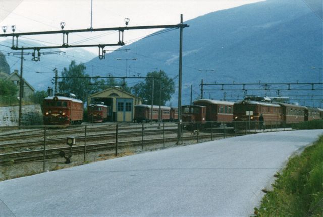 På jernbanestationen i Flåm holder en morgen alle tre ellokomotiver samt en akkumulatorrangermaskine. Uden for synsfeltet holdt nogle motorvejssæt, så banen var rustet til krydstogtturister. Foto fra 1983.