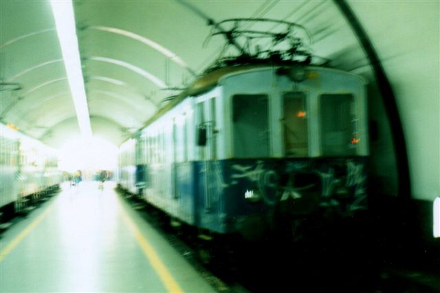 På den underjordiske station Roma Nord ses en aldrende motorvogn 112 med et myldretidstog til Viterbo. Jeg har desværre ikke formået at holde apparatet roligt længe nok. Vi er før det digitale apparat. 1998.