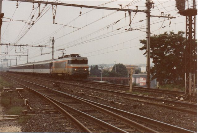 SNCF BB 7381 ned 6-vogntog til Strassbourg. Man ser et langt midliggende overhalingsspor samt et af to inustrispor. Bemærk stangtrækket til skifterne og signalerne til industrisporene.