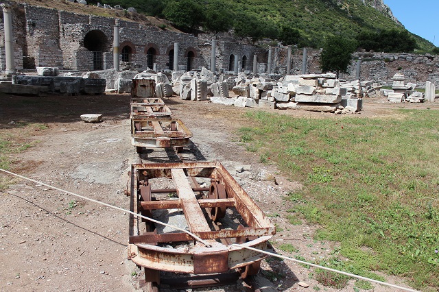 En hel række af smalsporvogne opstillet midt i ruinbyen. 2014.
