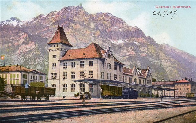 Grarus 517. Glarus i kantonen af sammen navn ligger nordvest for Chur. Stationen ligger på en normalsporet statsbane. Et damplokomotiv og et par godsvogne ses. Postkort købt 1907.