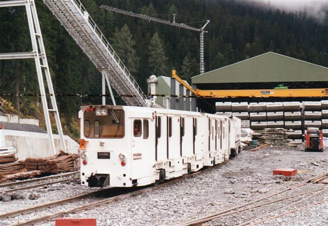 Foruden adskillige tunneler på Gotthardbanen bygget af endnu flere firmaer, byggedes også en genvej for Räthische Bahn, Vereinatunnelen, der byggedes fra både nord og syd. Her ArGe Vereinn Nord  i Klosters ses Schöma 5023/1989. Det er motovognen i bag. Forrest en styrevogn. Sættet startede ved Storebæltstunnelen som MTG 35-06, kom derefter til Kanaltunnelen  som TML RU 006 A + B. I Klosters ses ikke noget nummer. Sættet bruges til mandskabstransporter. I baggrunden tunnelelementer. Foto Ulrich Völz 1995. Negativ 627/24.