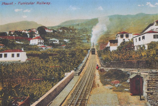 Affoto af postkort (tidligt farvefoto/håndcoloreret?) af banen med tog ved en af mellemstationerne. Ukendt tidspunkt.