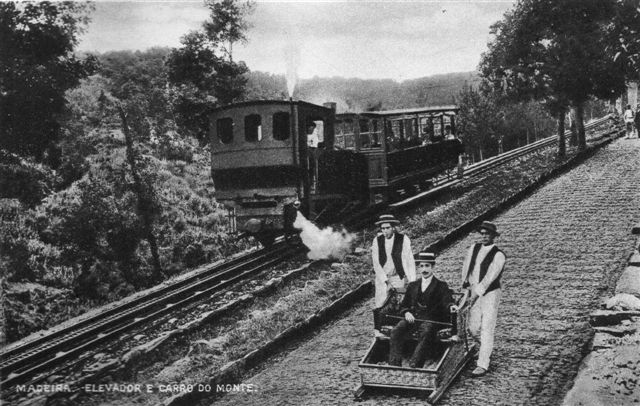 Lokomotiv skubber én personvogn op mod Monte. En slæde er på vej ned. Der er endnu brosten på vejen. Skanning af originalt postkort. Tidspunket er vel omkring Første Verdenkrig.