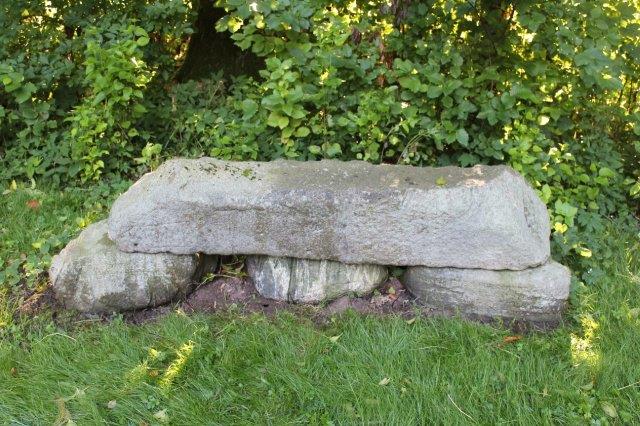 Stenen ligner mest en havebænk, og man skal se godt efter, for at få øje på runerne samt på teksterne på de to yderste bæresten.